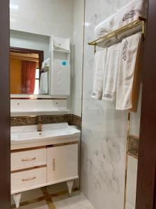 a bathroom with a sink and a mirror and towels at EL Faro RESORT AND SPA HOTEL in Nabran