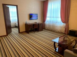 a hotel room with a desk and a table in a room at EL Faro RESORT AND SPA HOTEL in Nabran