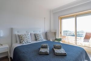 ヴィラ・ノヴァ・デ・ガイアにあるPorto Gaia River View 8 by MPのベッドルーム1室(大型ベッド1台、タオル2枚付)