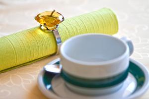 a ring on a napkin and a cup on a saucer at Appartementhaus Das Mittelpunkt in Mörbisch am See