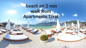 einen Strand mit Liegestühlen und Sonnenschirmen auf dem Sand in der Unterkunft Apartments Tivat in Tivat