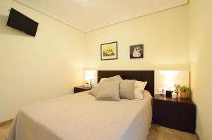 um quarto com uma cama branca com duas mesas de cabeceira em City Center Apartment em Valência