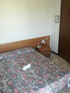 a bedroom with a bed with a floral bedspread at Maxi Heron in Lido di Jesolo