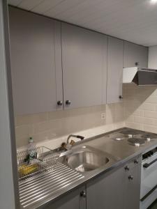 a kitchen with a stainless steel sink and white cabinets at Haus Opal Wohnung Nr. 31 in Grächen +45 photos