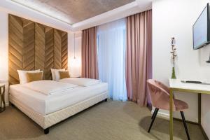 a hotel room with a bed and a television at Filitti Boutique Hotel in Bucharest