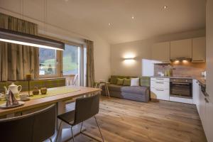 a kitchen and living room with a table and a couch at Haus Kreidl in Schwendau