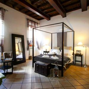 1 dormitorio con cama con dosel y espejo en Magenta Collection Purificazione, en Roma