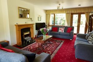 a living room with two couches and a fireplace at Rowans Inverness in Inverness