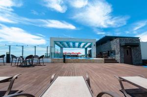 a deck with tables and chairs on top of a building at Vistacay Hotel Worldcup in Seogwipo