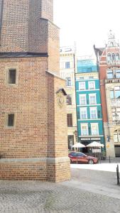un edificio di mattoni con un orologio sul lato di Academus Pub & Guest House a Breslavia