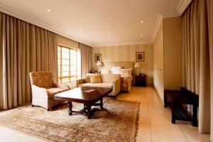 salon z kanapą i łóżkiem w obiekcie Birdwood Boutique Estate w mieście Pretoria