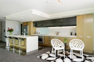 
a kitchen filled with white cabinets and white appliances at Sacred Waters Taupo in Taupo
