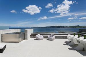 un patio con sillas y vistas al agua en Sacred Waters Taupo, en Taupo