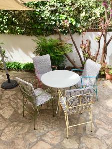 einen weißen Tisch und Stühle mit einem weißen Tisch und Stühlen in der Unterkunft El jardí de l'avet in Lleida