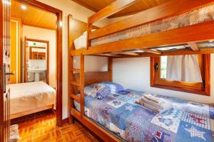 ヴィエイラ・ド・ミーニョにあるCasa das Bonecasのベッドルーム1室(二段ベッド2台、鏡付)