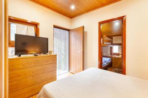 una camera da letto con un letto e una TV a schermo piatto di Casa das Bonecas a Vieira do Minho