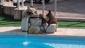 a giraffe sitting next to a water fountain at B&B Villa Nonna Maria in Castellana Grotte