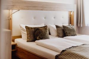 a bedroom with two beds with pillows at Hotel Frauensteiner Hof in Frauenstein