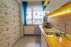 une cuisine avec un évier et un mur orné d'écritures. dans l'établissement Asbóth Taylor Apartment, à Budapest