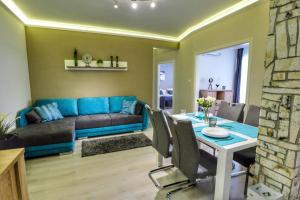 a living room with a blue couch and a table at Asbóth Taylor Apartment in Budapest