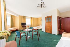 pokój hotelowy z łóżkiem, stołem i krzesłami w obiekcie Hotel Arkadia w Warszawie