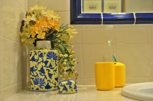 a blue and white vase with flowers and a toothbrush in it at Quinta do Freixieiro in Cinfães
