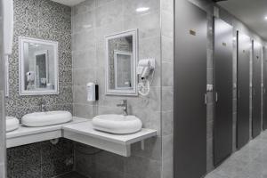 a bathroom with two sinks and two mirrors at Hostel Inbox in Skopje