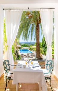 a white table and chairs on a patio with a palm tree at Son Colom Turismo de interior Bed & Breakfast in Campanet