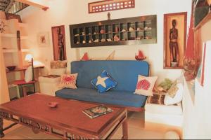 a living room with a blue couch and a table at Villa Valiha Boutique Hotel in Madirokely