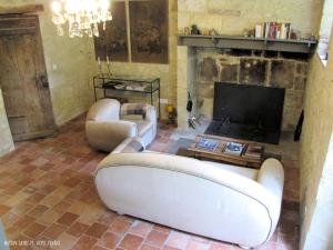 a living room with a couch and a fireplace at Maison Saint-Pé (Gers) in Béraut