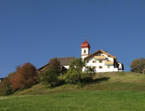 un edificio blanco en la cima de una colina con césped en Appartment Kircherhof, en Laion