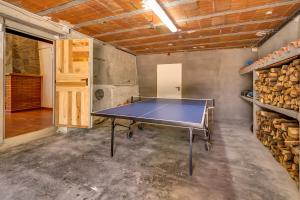 a ping pong table in a room with a stack of logs at Vivalidays Can Palomo in Palafolls +35 photos