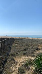 a beach with a wooden fence and the ocean at Studio entre lac et océan à Hossegor in Soorts-Hossegor