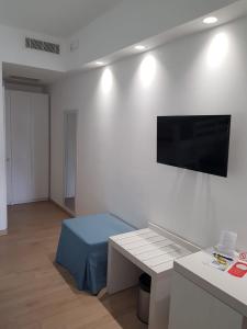 sala de estar con mesa y TV en la pared en Hotel Perla Gaia, en San Vito lo Capo