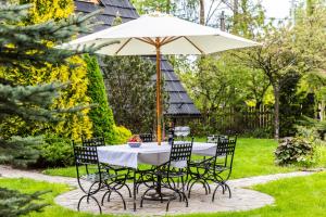 a table and chairs under an umbrella in a garden at udanypobyt Dom Z Ogrodem in Zakopane