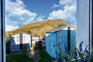 a building with a mountain in the background at Holyrood Skyline Apartment in Edinburgh