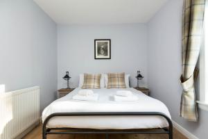 a bedroom with a white bed with two pillows at Holyrood Skyline Apartment in Edinburgh