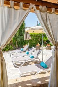 a row of lounge chairs and umbrellas on a beach at Son Colom Turismo de interior Bed & Breakfast in Campanet