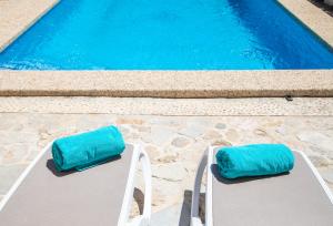 two chairs with blue cushions sitting next to a swimming pool at Son Colom -Turismo de interior in Campanet