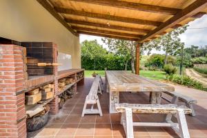 a wooden table and benches on a patio at Vivalidays Can Palomo in Palafolls