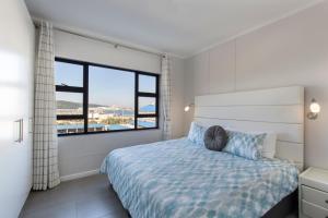 a bedroom with a bed and a large window at Stay at The Point - Spacious Sublime Stunner in Durban