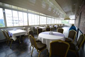 a dining room with tables and chairs and windows at Özdemir Palas in Ankara