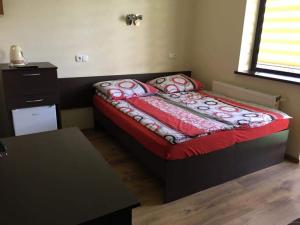 a small bedroom with a bed with a red comforter at Pokoje Gościnne u Lidki in Władysławowo