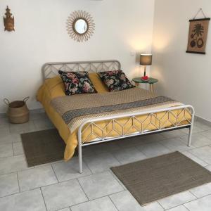 1 cama con marco de metal en un dormitorio en Maylou Baan, en Marseillan