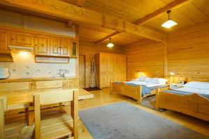 コシチェリスコにあるARKA POKOJE DE LUXのベッド2台、キッチンが備わる広い客室です。