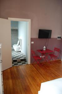 Cette chambre comprend une table et des chaises rouges ainsi qu'une baignoire. dans l'établissement La Boqueria, à Bra