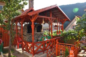 cenador de madera con chimenea en el patio en Pensiunea Lala, en Băile Tuşnad