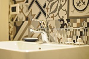 een wastafel in de badkamer met een kraan en een spiegel bij La Boqueria in Bra
