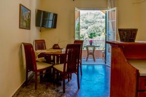 comedor con mesa, sillas y ventana en Naftis Apartments en Pelekas