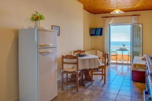 een keuken en eetkamer met een koelkast en een tafel bij Naftis Apartments in Pelekas